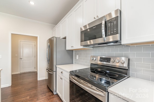 kitchen with backsplash, white cabinetry, stainless steel appliances, and ornamental molding