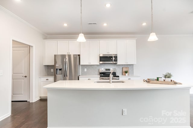 kitchen with stainless steel appliances, sink, an island with sink, and hanging light fixtures