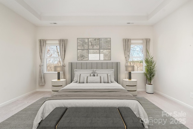 carpeted bedroom with crown molding, a raised ceiling, and multiple windows