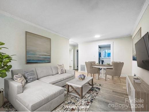 living room with hardwood / wood-style flooring and crown molding