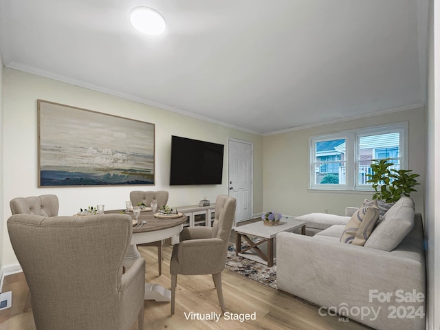 living room with light wood-type flooring and ornamental molding