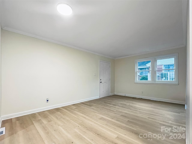 unfurnished room featuring light wood-type flooring and crown molding