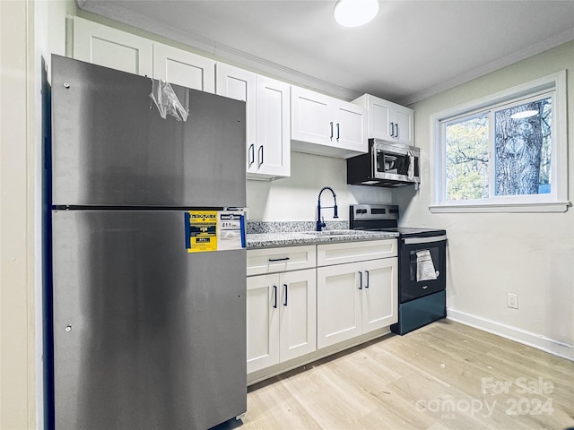 kitchen featuring white cabinets, light hardwood / wood-style floors, ornamental molding, and appliances with stainless steel finishes