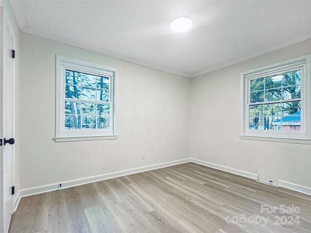 unfurnished room featuring light hardwood / wood-style flooring and crown molding