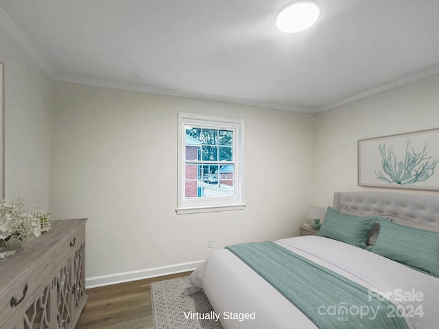 bedroom with dark hardwood / wood-style flooring and ornamental molding