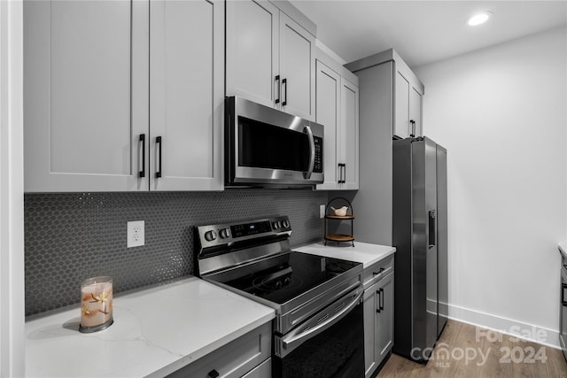 20 Heartleaf Cir Lot 7, Arden, NC 28704 - kitchen with stainless steel appliances, light wood-style flooring, backsplash, light stone countertops, and recessed lighting