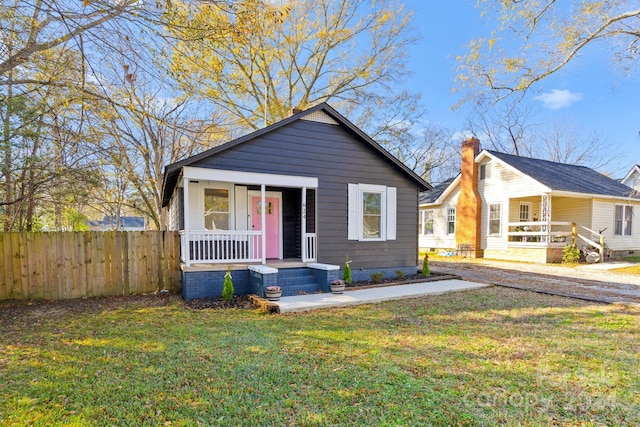 bungalow featuring covered porch and a front yard