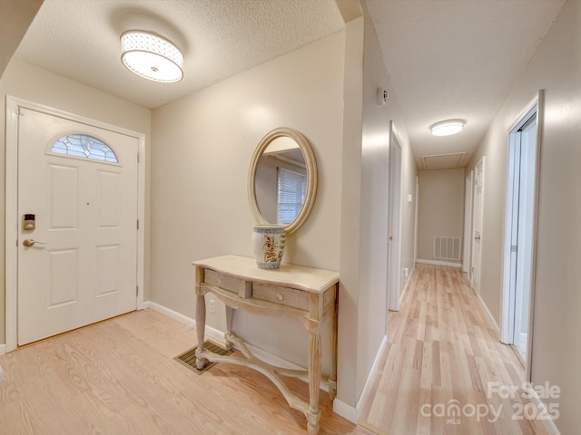 foyer featuring a textured ceiling and light hardwood / wood-style flooring