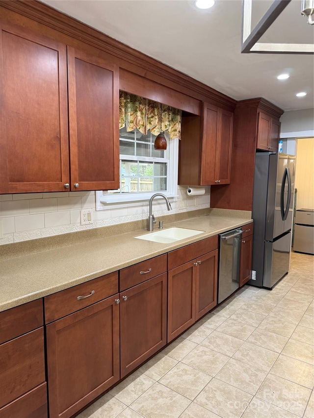 kitchen featuring backsplash, light tile patterned floors, sink, and appliances with stainless steel finishes