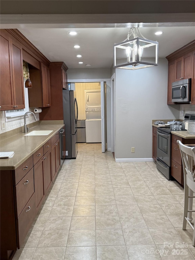 kitchen with sink, hanging light fixtures, stainless steel appliances, an inviting chandelier, and light tile patterned floors