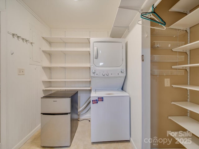 laundry area featuring ornamental molding and stacked washer and dryer