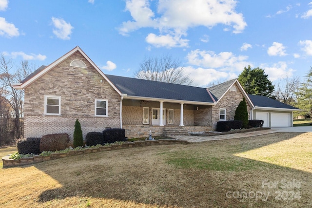 view of front of home featuring a porch, a garage, and a front lawn