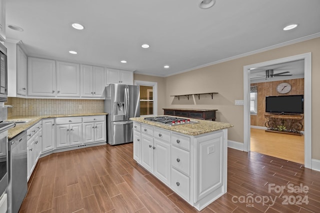 kitchen featuring white cabinetry, stainless steel appliances, decorative backsplash, a kitchen island, and hardwood / wood-style flooring