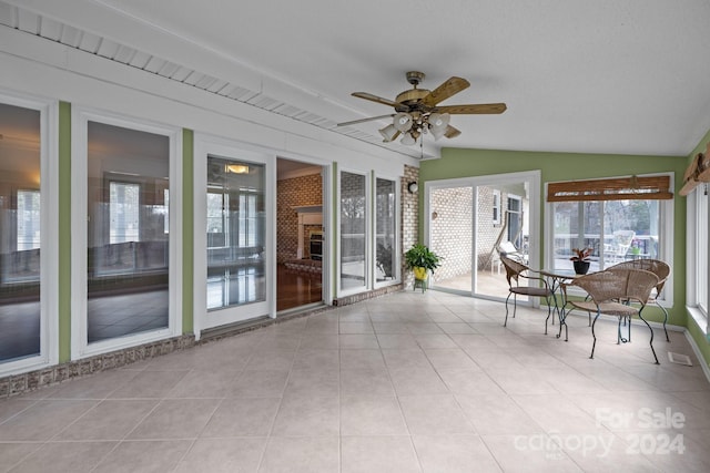 unfurnished sunroom with ceiling fan and lofted ceiling