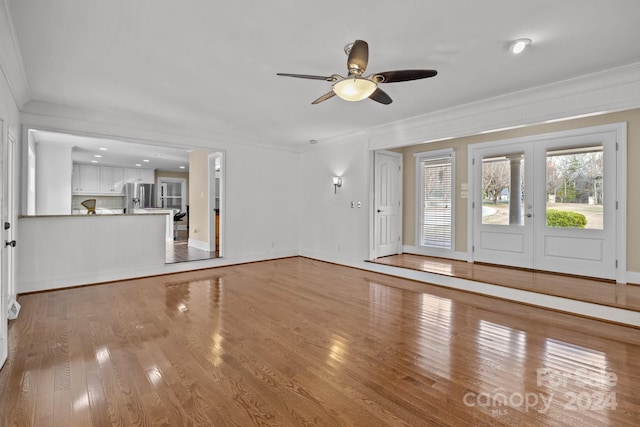 unfurnished living room featuring ceiling fan, light hardwood / wood-style flooring, french doors, and ornamental molding