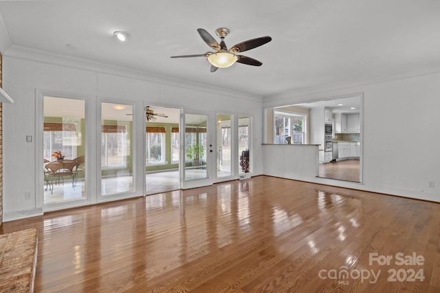 unfurnished living room featuring hardwood / wood-style flooring, ceiling fan, and ornamental molding