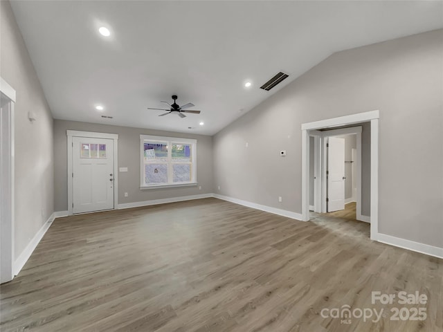 unfurnished living room featuring ceiling fan, lofted ceiling, and light wood-type flooring