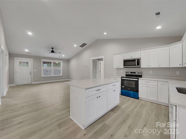 kitchen with stainless steel appliances, ceiling fan, light hardwood / wood-style flooring, white cabinets, and a center island