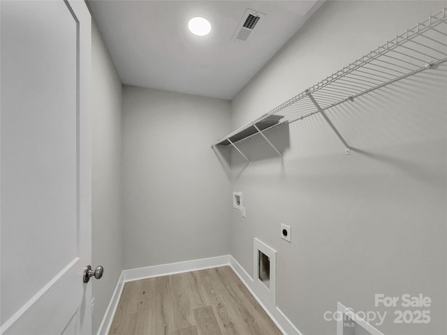 clothes washing area with washer hookup, electric dryer hookup, and light hardwood / wood-style floors