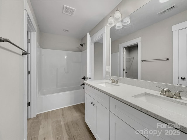 bathroom with shower / bathing tub combination, vanity, and hardwood / wood-style flooring