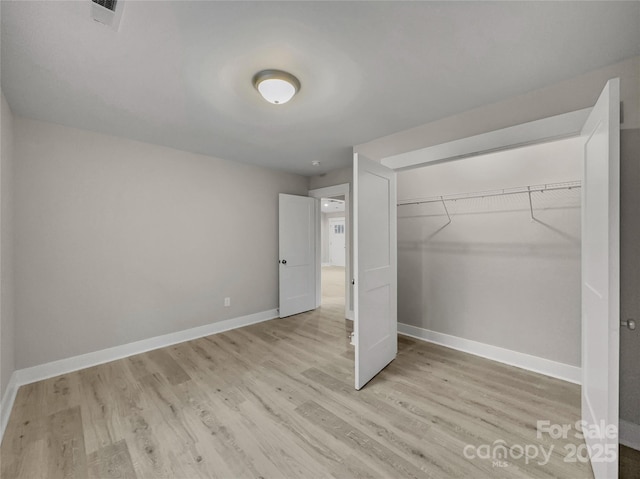 unfurnished bedroom featuring a closet and light wood-type flooring