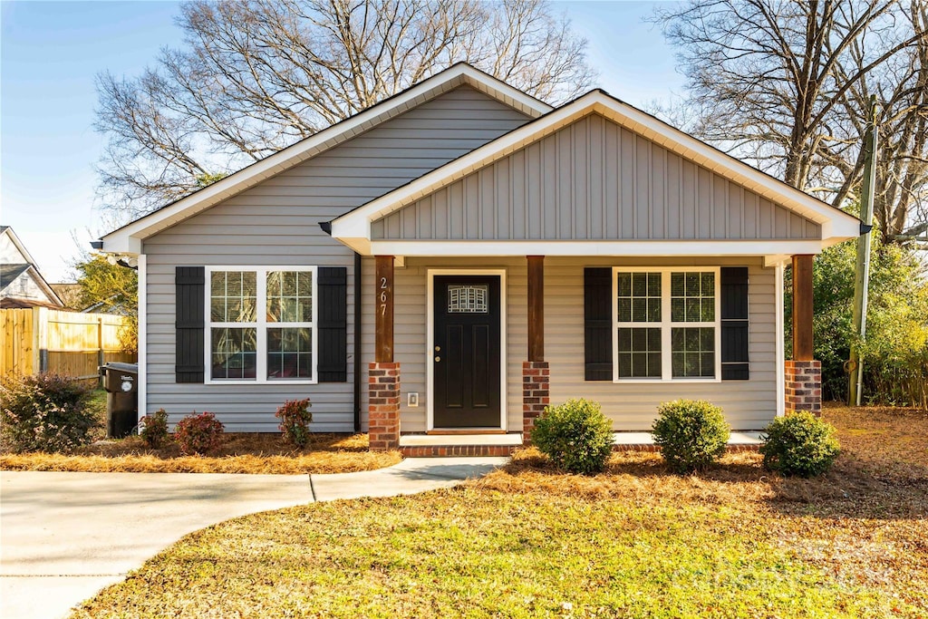 bungalow with a porch and a front lawn