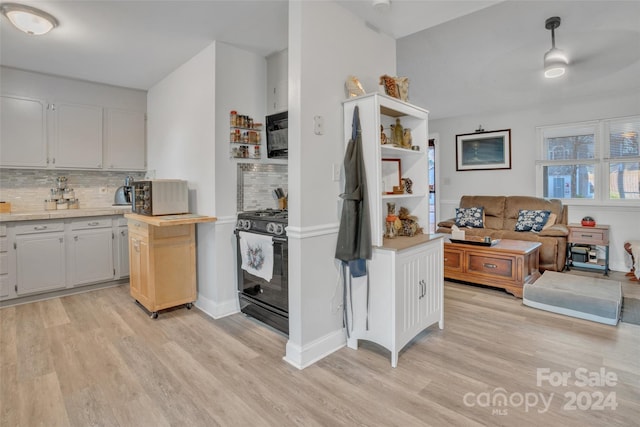 kitchen with black appliances, light hardwood / wood-style floors, and white cabinets