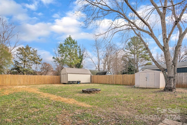 view of yard with a shed and an outdoor fire pit