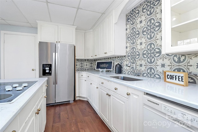 kitchen with white cabinetry, dark hardwood / wood-style flooring, stainless steel fridge, white dishwasher, and a paneled ceiling