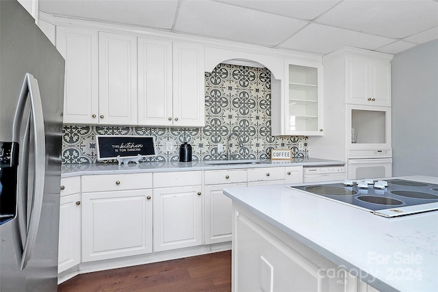 kitchen with white cabinetry, sink, a drop ceiling, tasteful backsplash, and white appliances