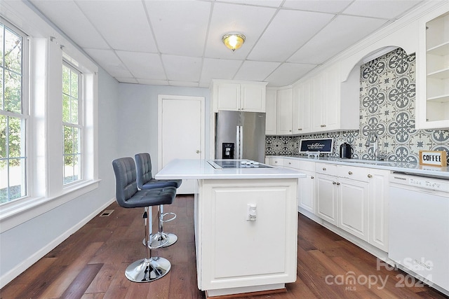 kitchen featuring white cabinetry, a drop ceiling, stainless steel fridge with ice dispenser, white dishwasher, and a kitchen island