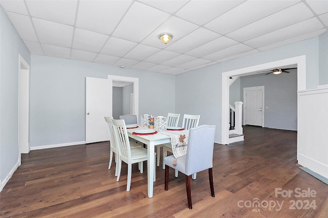 dining area with a paneled ceiling, ceiling fan, and dark hardwood / wood-style flooring