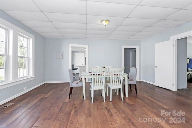 dining room with a paneled ceiling and dark wood-type flooring