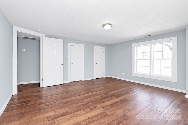 interior space with a textured ceiling and dark wood-type flooring