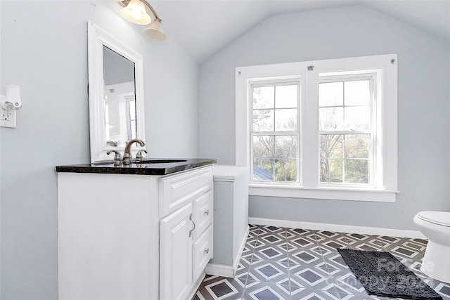 bathroom featuring vanity, toilet, and vaulted ceiling