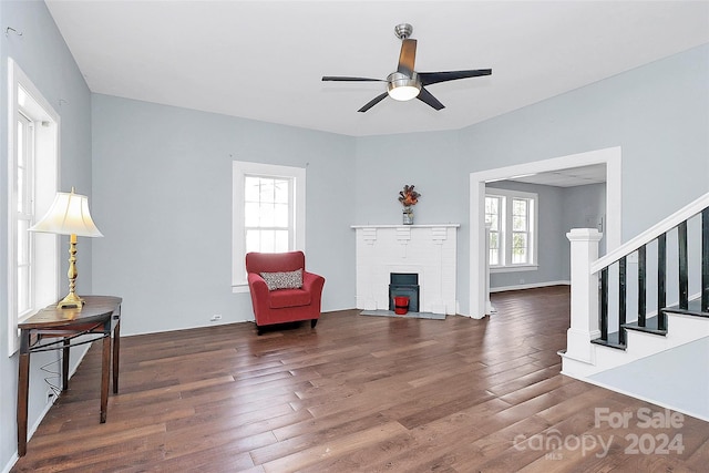 living area featuring dark hardwood / wood-style floors and ceiling fan