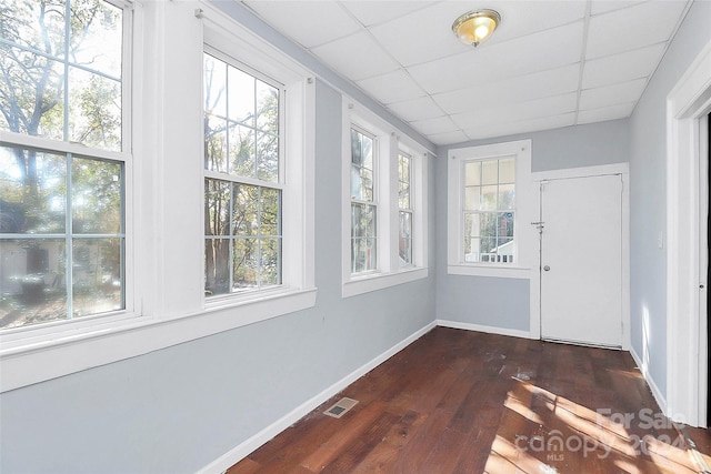 unfurnished sunroom with plenty of natural light and a drop ceiling