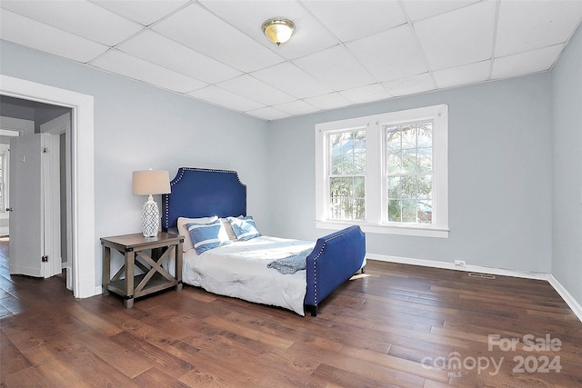 bedroom featuring dark hardwood / wood-style floors and a drop ceiling