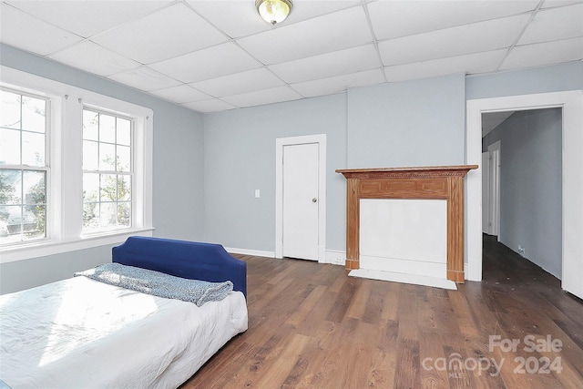 bedroom featuring dark hardwood / wood-style flooring and a drop ceiling