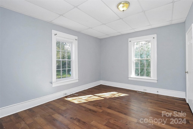 unfurnished room featuring hardwood / wood-style floors, a paneled ceiling, and plenty of natural light