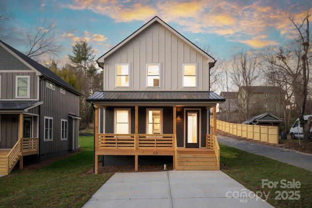 view of front of house featuring covered porch and a yard