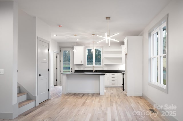 kitchen featuring white cabinets, plenty of natural light, pendant lighting, and sink