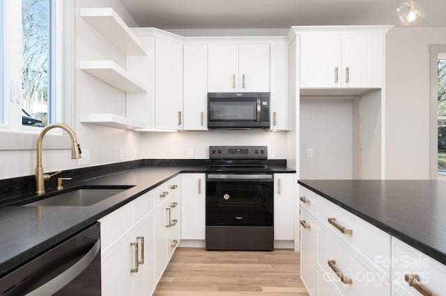 kitchen with a wealth of natural light, white cabinetry, sink, and appliances with stainless steel finishes