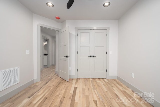 unfurnished bedroom with light hardwood / wood-style floors, a closet, and ceiling fan