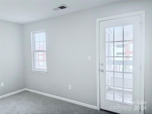 doorway with a wealth of natural light and carpet floors