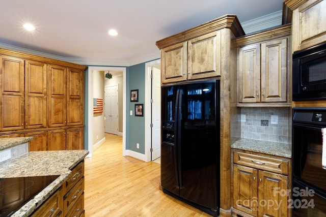 kitchen featuring decorative backsplash, light hardwood / wood-style flooring, ornamental molding, and black appliances