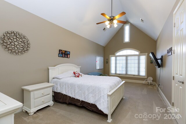 carpeted bedroom with ceiling fan, high vaulted ceiling, and a closet