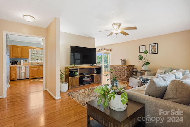 living room with light hardwood / wood-style floors, ceiling fan, and sink