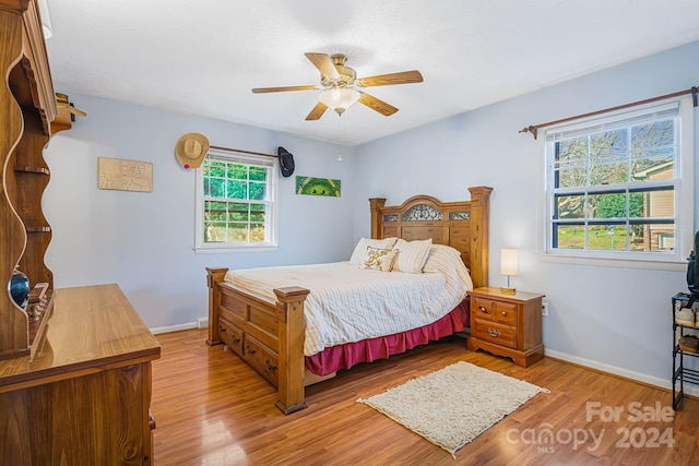 bedroom featuring multiple windows, ceiling fan, and light hardwood / wood-style flooring