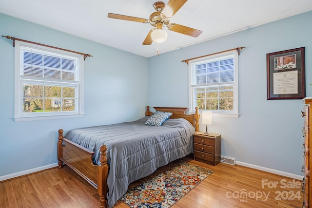 bedroom featuring multiple windows, ceiling fan, and light hardwood / wood-style flooring